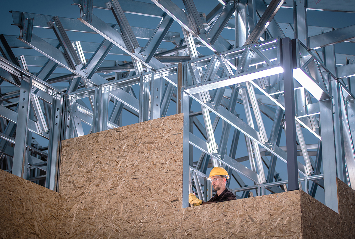 Metal and Wood Construction. Skeleton Frame of the Building and Caucasian Worker.