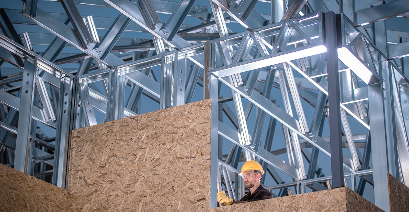 Metal and Wood Construction. Skeleton Frame of the Building and Caucasian Worker.